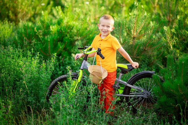 Menino Feliz Roupas Laranja Sentado Uma Bicicleta Grama Verde Verão — Fotografia de Stock