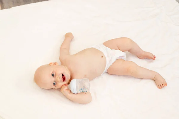 Αγοράκι Μηνών Ξαπλωμένο Πάνες Λευκό Κρεβάτι Ένα Μπουκάλι Γάλα Στο — Φωτογραφία Αρχείου