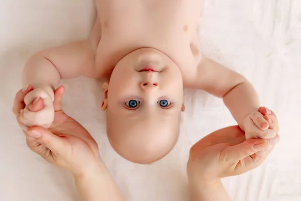 Una Madre Sostiene Las Manos Bebé Sonriente Una Cama Blanca — Foto de Stock