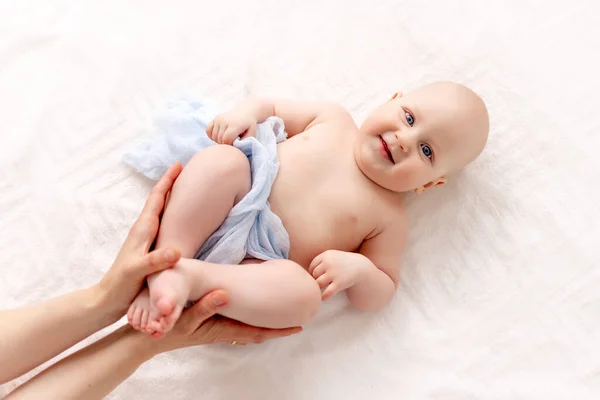 Bir Anne Bebeğinin Bacaklarını Nazikçe Tutar Gülümseyen Bir Çocuk Beyaz — Stok fotoğraf