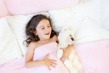 Sabah uyanan küçük kız yatakta.
