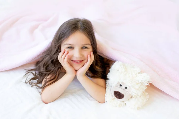 Egy Kis Mosolygós Lány Éves Fekszik Ágyban Egy Teddy Macival — Stock Fotó