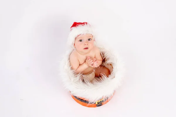 Uma Menina Pequena Senta Chapéu Papai Noel Fundo Isolado Branco — Fotografia de Stock