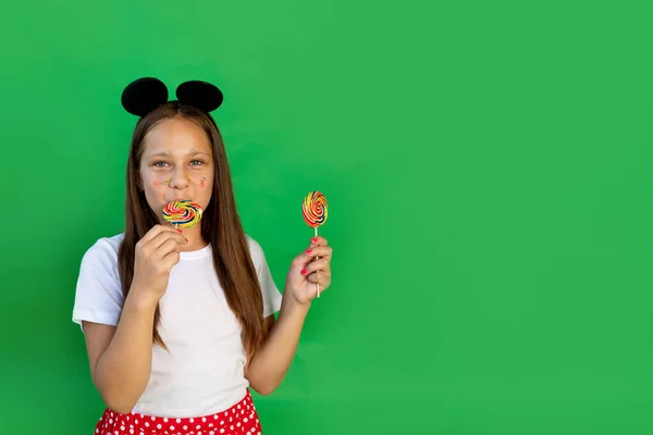 Ένα Χαρούμενο Κοριτσάκι Ένα Πράσινο Απομονωμένο Φόντο Τρώει Και Ενδίδει — Φωτογραφία Αρχείου
