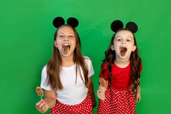 Χαριτωμένα Κοριτσάκια Ένα Πράσινο Απομονωμένο Φόντο Τρώνε Μεγάλα Γλειφιτζούρια Και — Φωτογραφία Αρχείου
