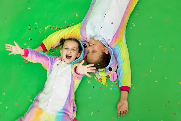 Kleine Meisjes Heldere Kostuums Liggen Een Groene Geïsoleerde Achtergrond Met — Stockfoto