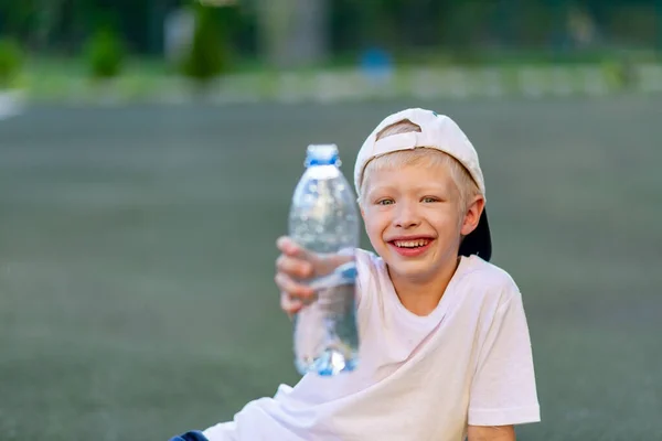 Portret Van Een Blonde Jongen Een Sportuniform Zittend Een Groen — Stockfoto