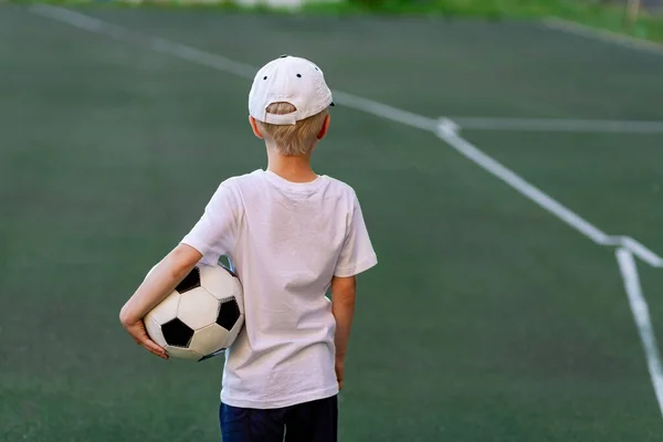 Хлопчик Спортивному Одязі Сидить Зеленому Газоні Футбольному Полі Футбольним Ячем — стокове фото