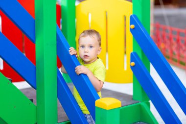 Küçük çocuk oyun alanında oynuyor.