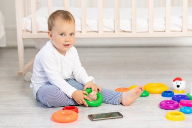 Küçük bir çocuk. 2 yaşında. Beşiğin yanında oynuyor.