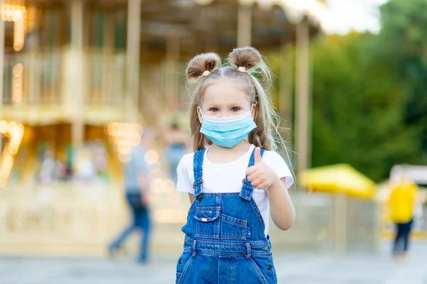 Bir Kız Bebek Eğlence Parkında Koruyucu Bir Maske Takıyor Baş — Stok fotoğraf