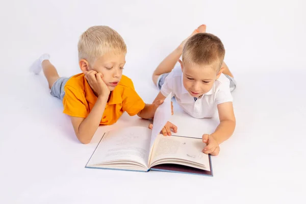 Twee Kleuters Broer Jongens Liggen Een Witte Geïsoleerde Achtergrond Lezen — Stockfoto