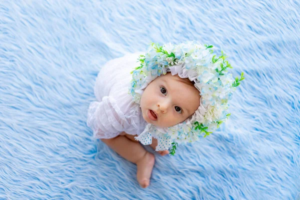 Una Bella Bambina Siede Tappeto Blu Soffice Cappello Fatto Fiori — Foto Stock