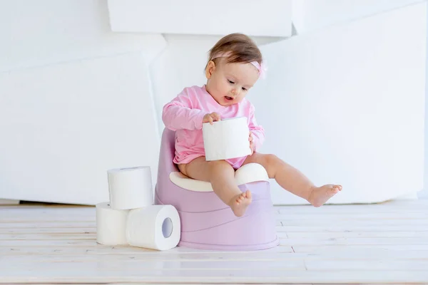 Een Klein Meisje Zit Een Potje Roze Kleren Een Lichte — Stockfoto