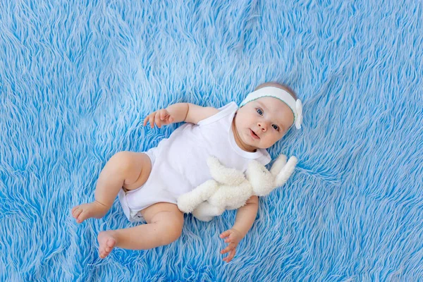 Smiling Child White Bodysuit Lies Blue Fur Background Toy — Stock Photo, Image