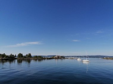 Küçük tekneler ve güzel bir yaz gününde gölde bir ada.