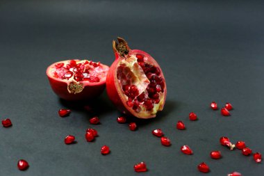 Karanlık arka planda izole edilmiş sulu nar meyvesi. Sağlıklı meyveler, göğüs kanserine karşı yiyecekler, koyu arka planda parlak sulu olgun nar meyveleri. Nar reyonunda olgun kehribar renkli böğürtlenler görülebilir..