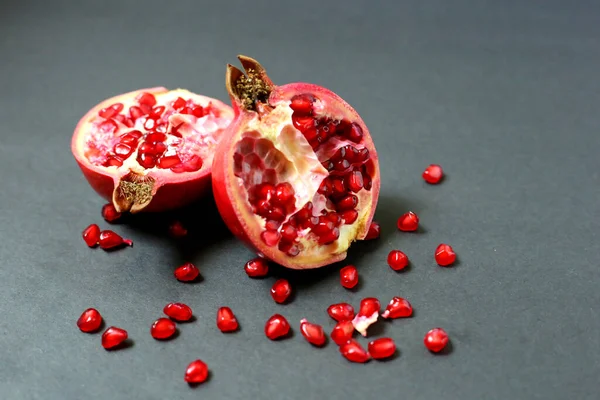 Juicy pomegranate fruit isolated on dark background. healthiest fruits, food Against Breast Cancer, Bright juicy ripe pomegranate fruit on a dark background. In the pomegranate section, ripe amber-colored berries are visible.