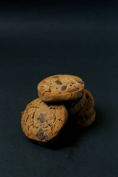 Chocolate cookies on black background. Chocolate chip cookie on black background with copy space for text, closeup.