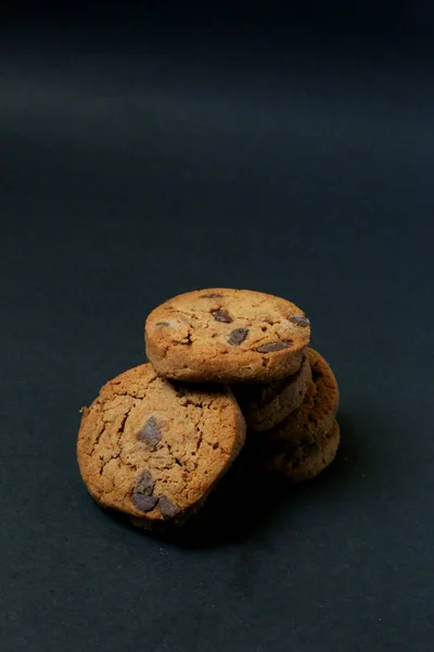 Chocolate cookies on black background. Chocolate chip cookie on black background with copy space for text, closeup.