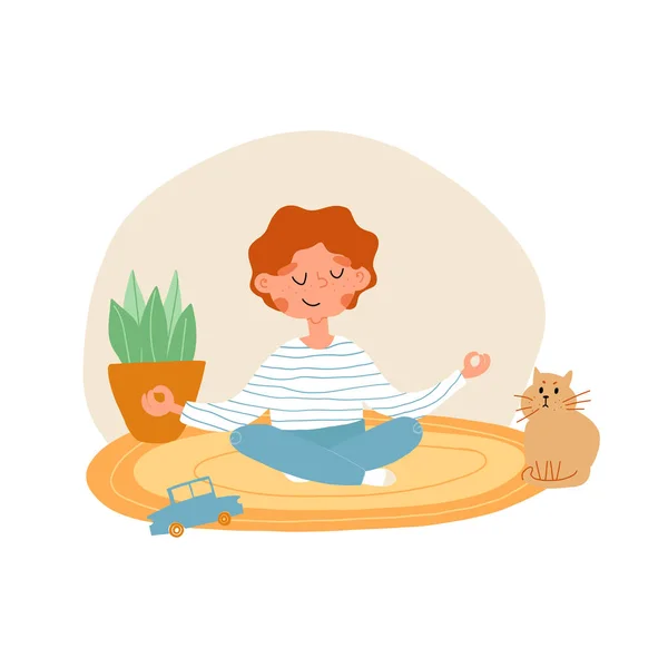 Aranyos vörös hajú srác csíkos mellényben és farmerben letesz egy játékot, és lótuszpózban meditál, a macska a közelben ül és úgy néz ki,. — Stock Vector