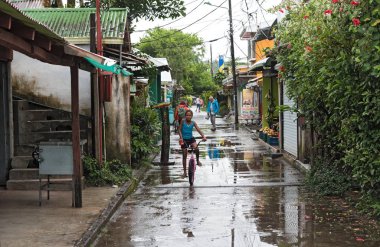 TORTUGUERO VILLAGE, COSTA RICA-MARCH 21, 2017: Road in tortuguero village at rainy weather, Costa Rica clipart