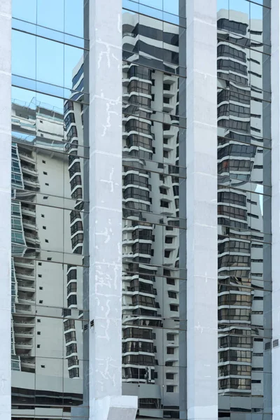 Reflejo de una casa vecina en la fachada de un rascacielos — Foto de Stock