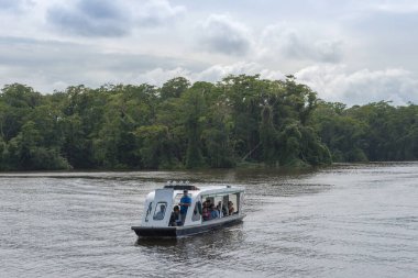 TORTUGUERO VILLAGE, COSTA RICA-MARCH 21, 2017: Kosta Rika 'da Tortuguero Ulusal Parkı' nı ziyaret eden kimliği belirsiz insanlarla dolu bir turizm teknesi