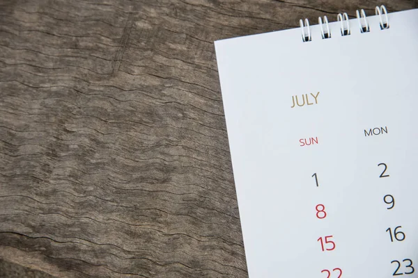 Close up July calendar on wood texture.