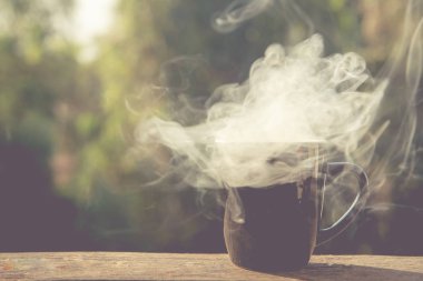 coffee cup with white smoke on blur background.Pastel tone.
