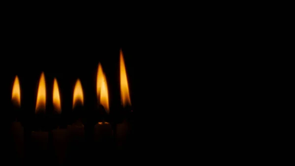 Verschwommenes Kerzenlicht auf schwarzem Hintergrund. — Stockfoto