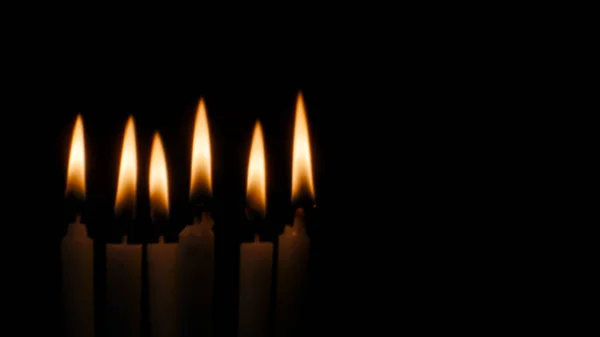 Verschwommenes Kerzenlicht auf schwarzem Hintergrund. — Stockfoto