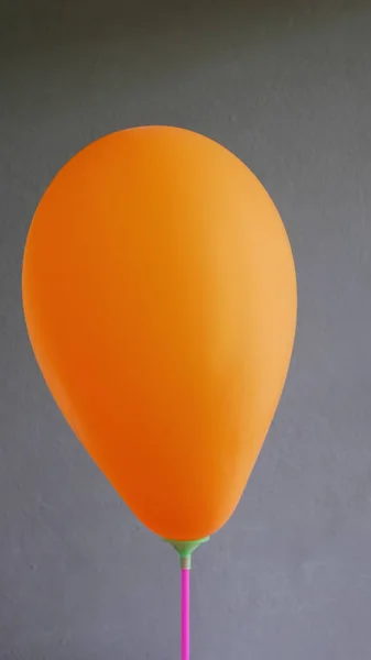 Zbliżenie pomarańczowy balon na szarym tle. — Zdjęcie stockowe