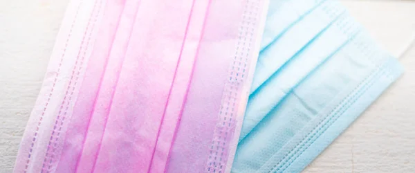 模糊背景下的粉色和蓝色外科口罩 Covid 19概念 — 图库照片