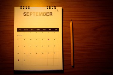 Planlama kavramında ahşap masada bulanık takvim.