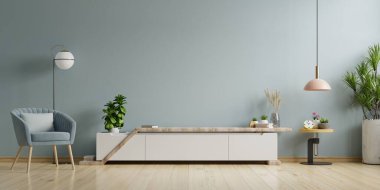 Modern oturma odasındaki kabine TV boş mavi duvarlı arka planı olan parlak bir oturma odası. 3B görüntüleme