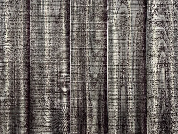 A close up section of vertical overlapping wooden fencing panels in grey with knots