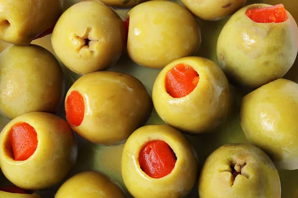 A close up of stuffed green olives with pimento filling