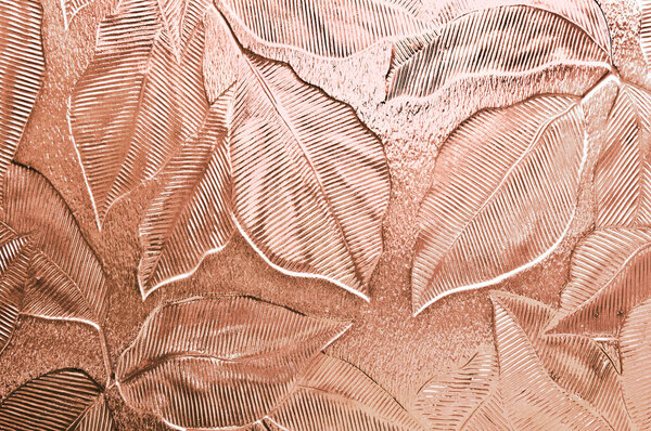 Крупный план тисненой двери или окна стекла с рисунком листа тонированный персиковый розовый
