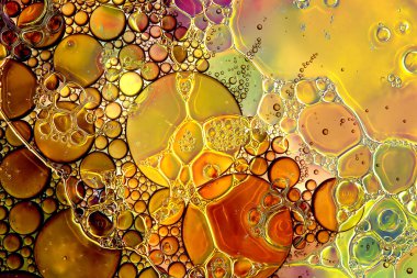 Kırmızı ve altın tonlarında, yağ ve su karışımından oluşan bir makro fotoğraf.