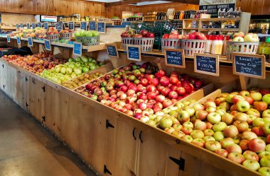 Lancaster County, Pennsylvania 'daki yerel bir çiftçi pazarında ahşap vitrinlerde çeşitli elma ve şeftali çeşitleri