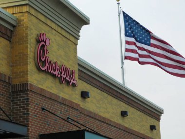 Pensilvanya, Lancaster 'daki Belmont Alışveriş Merkezi' nde rüzgârda uçuşan Amerikan bayrağıyla Chick-fil-A fast food restoranının manzarası.