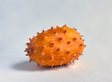 İzole edilmiş kiwano meyvesi beyaz arka planda, güneş ışığıyla