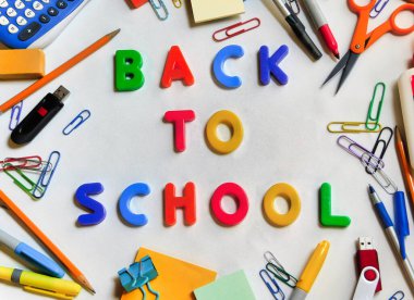 Çeşitli okul malzemeleriyle çerçevelenmiş, beyaz zemin üzerinde 