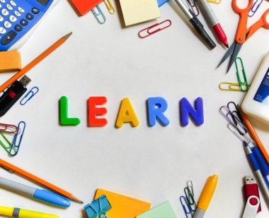 Beyaz arka planda, çeşitli okul malzemelerinden oluşan çerçevenin ortasında doğal ışık ile aydınlatılmış 