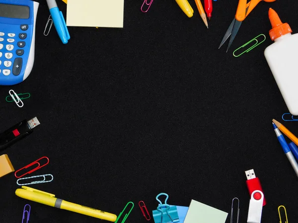 Frame of school supplies on balck backdrop, copyspace in middle of frame