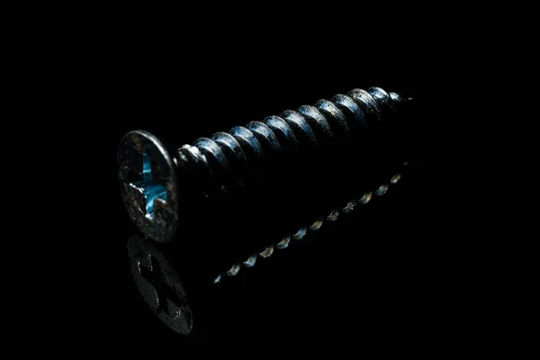Eine Isolierte Schraube Auf Einer Reflektierenden Oberfläche Mit Dunklem Hintergrund — Stockfoto
