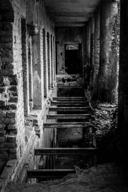 Kırılgan duvarları paralel ve duvarlardan gelen güneş ışığı olan terk edilmiş eski bir perili ev. Tek renkli çekim.