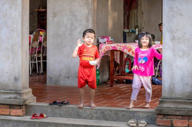Mang Thit, Vinh Long / Vietnam - 4 Mart 2019: Mekong Deltası yakınlarında turistlere el sallayan iki oyuncu çocuk.