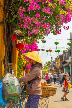 HOI AN / VIETNAM - Mart 06 2019: Hoi 'de konik şapkalı bir kadın yemek satıyor.
